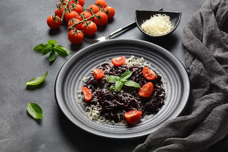 Squid Ink Pasta with , parmesan, basil leaves. Black spaghetti, black organic noodles . Mediterranean gourmet food.の写真素材