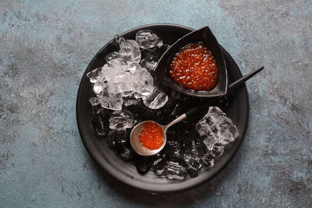 Delicious red caviar in a bowl with ice cubes