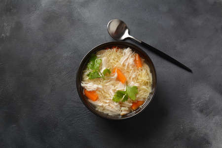 Chicken soup with noodles and vegetables in bowl. Healthy food conceptの写真素材