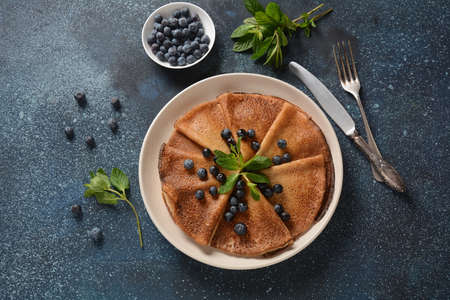 Sweet pancakes wrapped with fresh mint and blueberries. Healthy breakfast conceptの写真素材