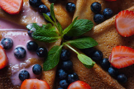 Sweet pancakes wrapped with fresh mint and blueberries. Healthy breakfast concept