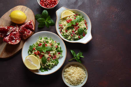 Healthy salad with couscous, fresh mint, cucumber, pomegranate, lemon and olive oil. Eastern...