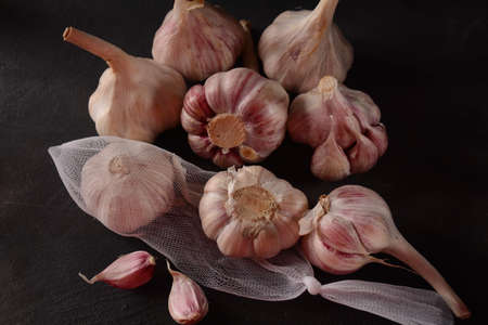 Fresh violet garlic bulbs  on a black backgroundの写真素材