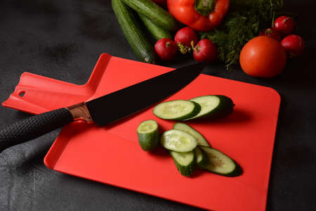 Fresh cucumbers and knife on a cutting board. Preparing, cooking  food concept