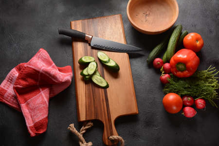 Cutting vegetables on a kitchen board. Preparing or cooking saladの写真素材