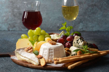 Cheese platter with assorted cheeses, grapes, nuts and snacks . Italian, French cheese starter....