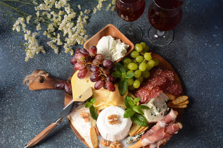 Appetizers table with snacks. Antipasto  Cheese Board, salami and prosciutto crudo with grissini...