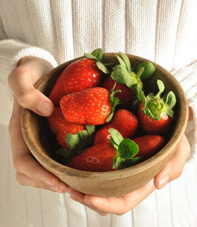Strawberries in child's hands. The girl is holding strawberries in hands. Healthy food