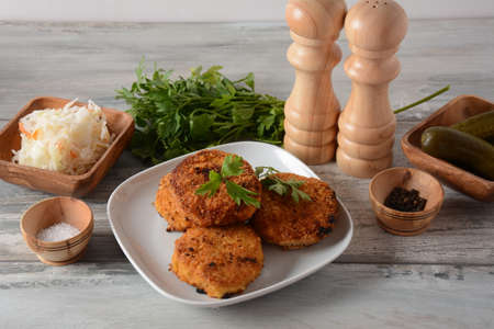Juicy fried homemade chicken cutlets. Coated with breadcrumbs, delicious, in white dish with herbs....