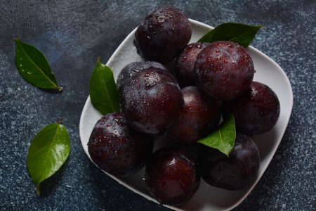Juicy plums in a plate. Fresh Blue plums.の写真素材