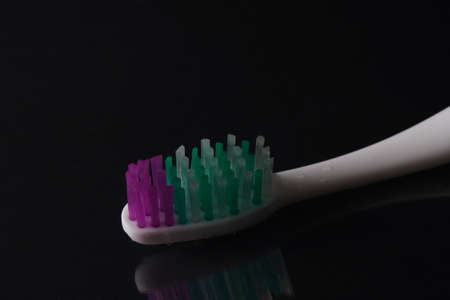 Toothbrush  on black background with water drops