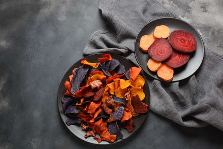 Baked vegetable chips- garnet sweet potato, purple sweet potato, carrot and beetroot. Gluten-free, dairy-free and vegan. Healthy food conceptの写真素材