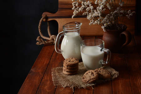 Chocolate chip cookies  with milk on rustic wooden tableの写真素材