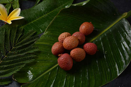 Fresh  lychee  showing the red skin  on leaf background.の写真素材