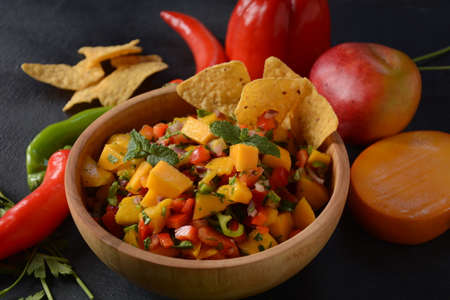 Grilled chicken breast with spicy salsa salad, mango, herbs, onions and peppers, corn chips. Mexican Food.の写真素材