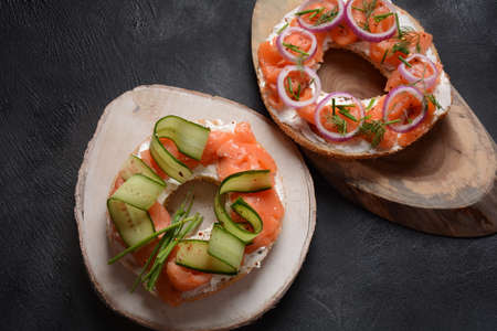 Bagel sandwich with salmon, cream cheese, cucumber, and onionsの写真素材