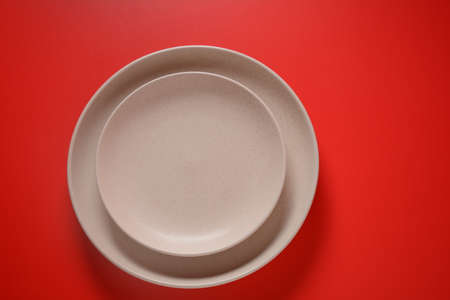 White  plates  napkin on red background. Setting up a table