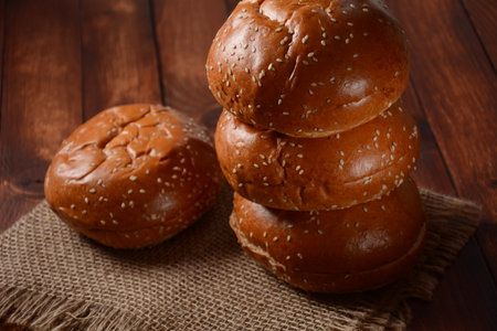 A stack of burger buns. Round bread on wooden boardの写真素材