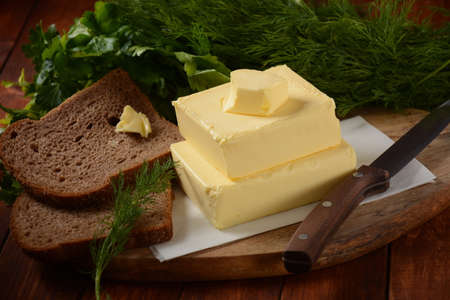 Butter. Slices of butter with parsley and bread
