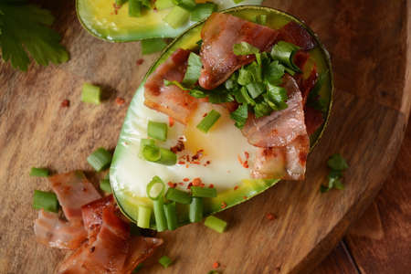 Baked avocado and eggs boats with bacon crumbles . Low carb high fat breakfastの写真素材