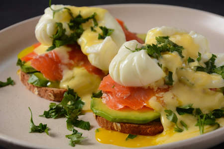 Eggs Benedict with smoked salmon, avocado slices and hollandaise sauceの写真素材