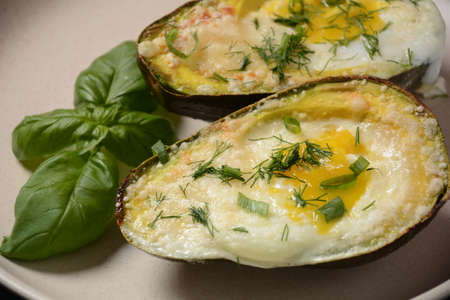Baked avocado and eggs boats with parmesan, basil