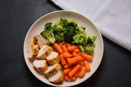 Grilled chicken fillet and vegetables broccoli and carrots boiledの写真素材