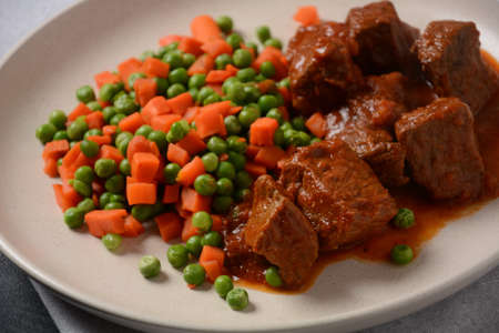 Spicy beef stew with boiled carrots and peas. Healthy foodの写真素材