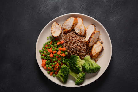 Healthy breakfast. Tasty buckwheat porridge, grilled chicken fillet and vegetables  boiledの写真素材
