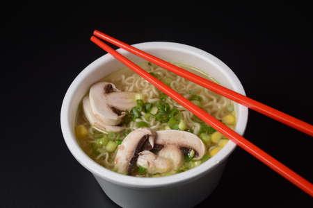 Noodles in plastic bowl, traditional asian meal on dark background, junk food conceptの写真素材
