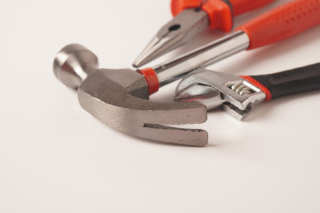 Hammer and Pliers and Adjustable wrench on white background. Close up image of standard claw hammer...