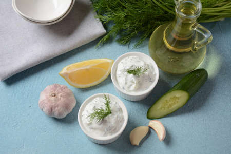 Traditional greek dip sauce or dressing tzatziki prepared with grated cucumber sour cream yogurt...