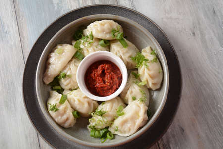 Homemade dumplings, Dagestan cuisine, Kurze. Dumplings kurze with meet filling, and adjika hot sauce  on a plateの写真素材