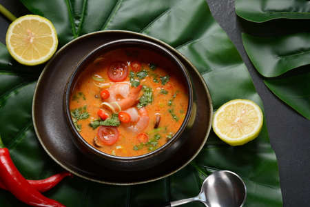 Tom Yam kung Spicy Thai soup with shrimps, coconut milk and chili pepper in bowl.の写真素材