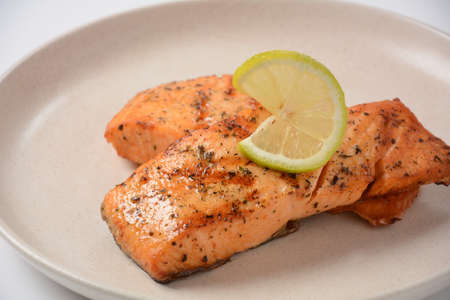 Fried salmon steaks. Cooked salmon steak with pepper, herbs, lemon, garlic, olive oil and Brussels sprouts. Grilled fresh fish.の写真素材