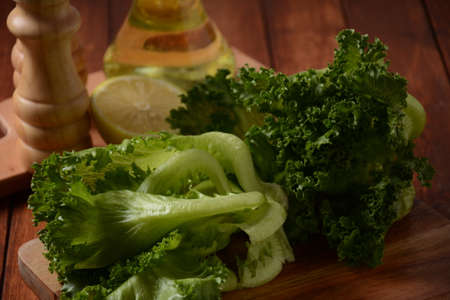 Green Batavia lettuce leaves on wooden background. Ready for cooking salad