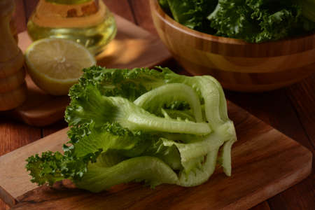 Green Batavia lettuce leaves on wooden background. Ready for cooking saladの写真素材