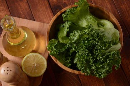 Green Batavia lettuce leaves on wooden background. Ready for cooking saladの写真素材