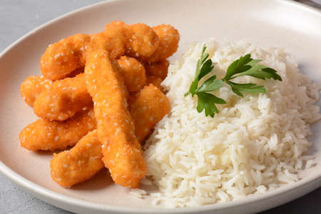 Chicken nuggets with rice and vegetables  on a white plate