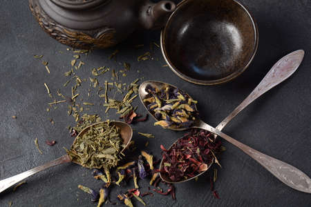 Various kinds of dry tea bancha green, Hibiscus, Butterfly Pea flower tea in spoons on the tableの写真素材