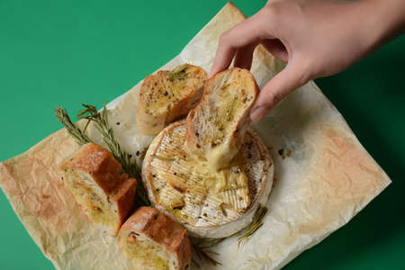 Baked camembert with toasts , rosemary on white cooking paperの写真素材
