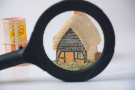 A house in magnifying glass. Mortgage concept. The concept of buying or renting a house, apartment, cottageの写真素材