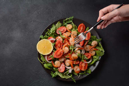 Fresh salad plate with shrimps, onions, lemon, tomatoes and mixed greens (arugula, mesclun, )の写真素材