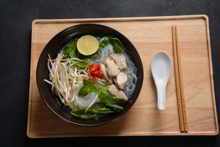 Pho Ga soup  with chicken, rice noodles and fresh herbs in a bowl. Vietnamese cuisineの写真素材