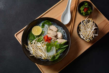 Pho Ga soup  with chicken, rice noodles and fresh herbs in a bowl. Vietnamese cuisineの写真素材