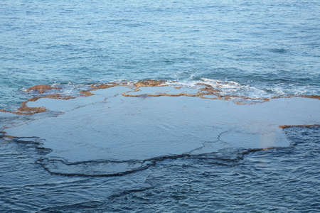 Sea Waves Crashing on the Rocks with White Foam. Swirling frothy foamy sea water over the rock near Akko(Acre) Israelの写真素材