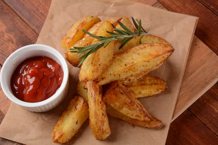 Baked, fried  potato  wedges with spices and rosemary