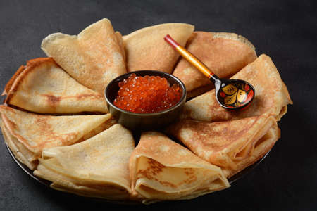 Pancakes with red caviar. Shrovetide Maslenitsa Week festival meal. Stack of Russian pancakes with red caviar. Rustic styleの写真素材