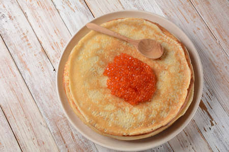 Pancakes with red caviar. Shrovetide Maslenitsa Week festival meal. Stack of Russian pancakes with...