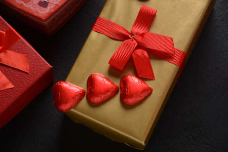 Love concept for Valentines day with sweet and romantic moment. The red Heart shapes sweets on dark...